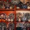 Collection of colorful İznik ceramics on display shelves in Bursa, showcasing traditional Turkish art.