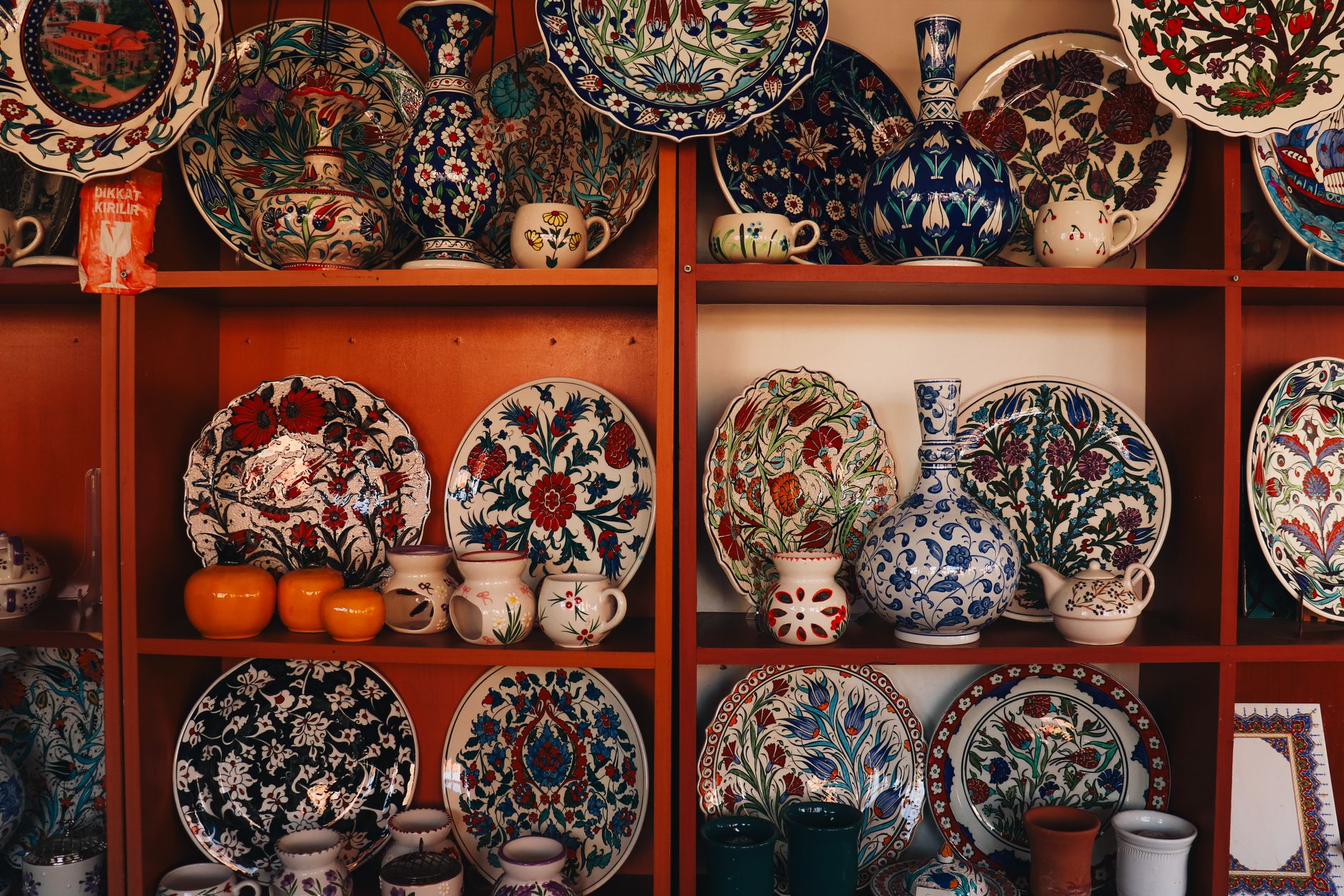 Collection of colorful İznik ceramics on display shelves in Bursa, showcasing traditional Turkish art.