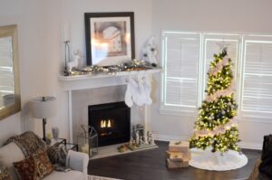Warm and inviting living room decorated for Christmas with a beautifully lit tree and fireplace.