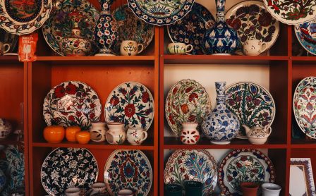 Collection of colorful İznik ceramics on display shelves in Bursa, showcasing traditional Turkish art.