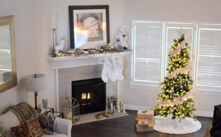 Warm and inviting living room decorated for Christmas with a beautifully lit tree and fireplace.